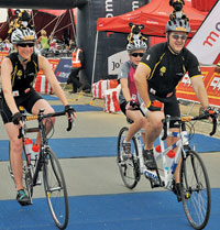 RS Components’ general manager Brian Andrew crosses the line riding tandem with daughter Tylor and alongside wife Corina